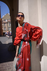 Fashion portrait of young spanish woman in sunglasses. Fashion latin look. Woman walking in old town