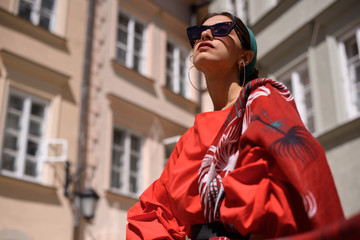 Fototapeta premium Fashion portrait of young spanish woman in sunglasses. Fashion latin look. Woman walking in old town