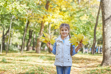 Beautiful happy girl in autumn park.