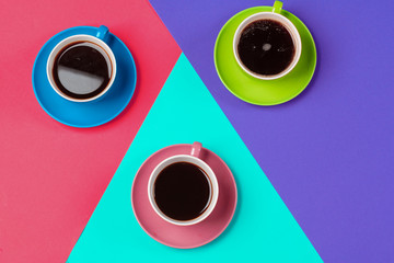 Colorful coffee cups and saucers on colorful vibrant background