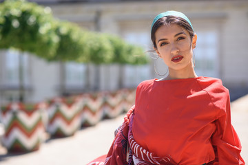 Young spanish woman in a red blouse and green pants. Fashion latin look. Flamenco woman smiling