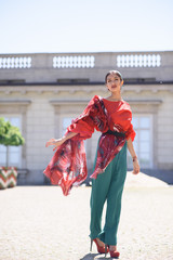 Young spanish woman in a red blouse and green pants. Fashion latin look. Flamenco woman smiling
