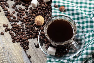 Cup of coffee and beans on wooden background