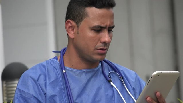 Serious Hispanic Male Surgeon With Tablet