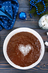 A big festive chocolate cake, a heart of coconut in the middle. The top view
