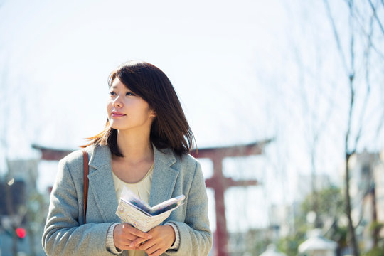 地図を確認しながら散策する20代女性