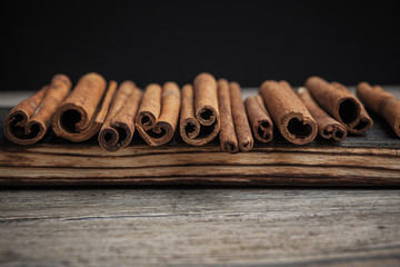 Cinnamon sticks on wooden background.