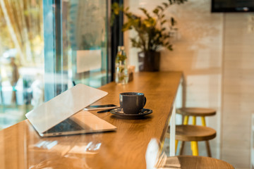 laptop, smartphone, notebook and cup of coffee on wooden cafe counter