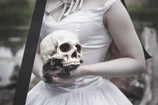 Human skull in creepy bride hands. Halloween concept