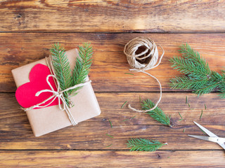 Geschenkpakt mit rotem Herz und Tannenzweigen weihnachtlich verpackt - obrazy, fototapety, plakaty