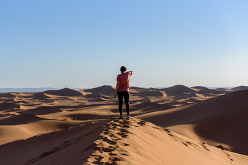 Fototapeta na wymiar Erg Chebbi, Sahara Desert in Morroco : October 24 2017 : woman in the desert of Sahara in Morocco.