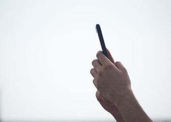 A man holding cellphone in the air