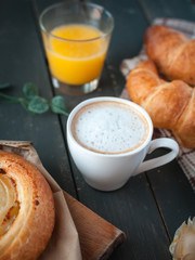Close-up of coffee with continental breakfast on dark background