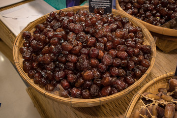 A fresh date-palm and dry date-palm on a wooden trays in the market.