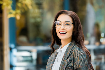 beautiful cheerful girl in stylish jacket and glasses