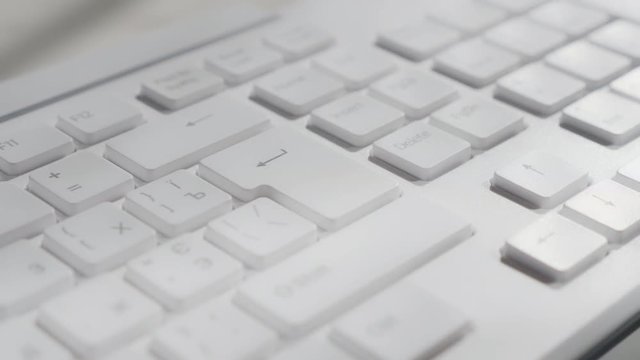 Pressing the enter key on a computer keyboard. Macro footage.