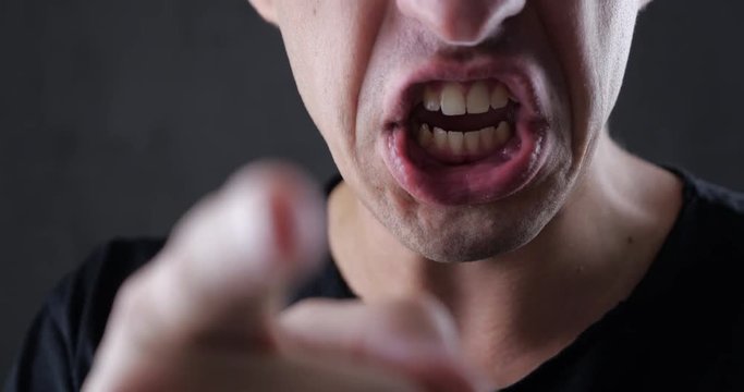 Closeup Man Speaks Aggressively and Threatens with his Finger. Danger Violence. To force, compel, dominate
