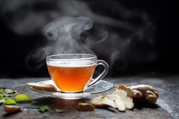 Hot Ginger tea in a glass on wood background.Hot drink . Copy space. - obrazy, fototapety, plakaty