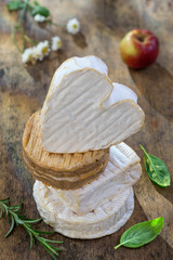 Norman cheese piled. French Normandy AOC soft pudgent wrapped Livarot ,Camembert, Pont-Leveque, Neuchatel,from Normandy, with apple decoration