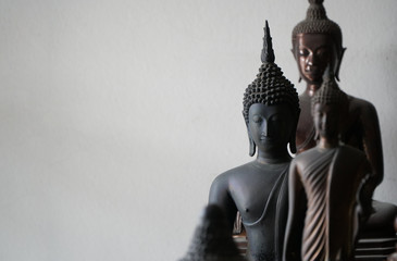 select focus of vintage black ancient buddhas statue in the middle of other buddhas statue