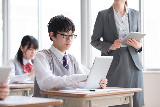タブレットPCで勉強をする学生と女性教師