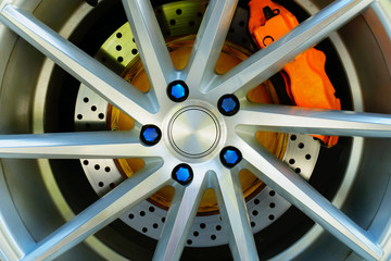 Sport car wheel and orange brake caliper , Blue wheel nut