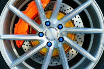 Sport car wheel and orange brake caliper , Blue wheel nut