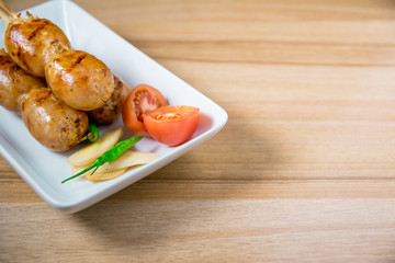 Grilled sausages on wooden board