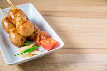Grilled sausages on wooden board