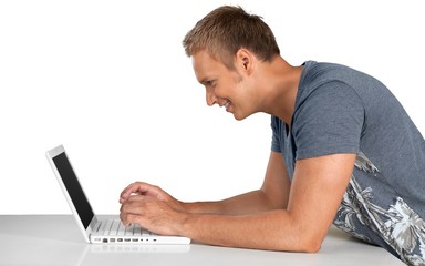 Portrait of young handsome businessman using laptop isolated on