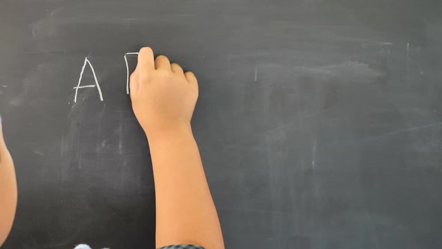 Hand of Boy asian children write the chalkboard. Education concept.