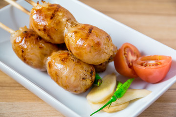 Grilled sausages on wooden board