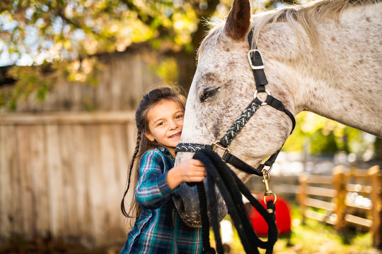 in a beautiful Autumn season of a young girl and horse