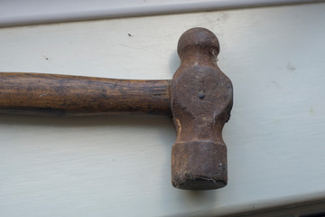 An old hammer head tool with a wooden handle