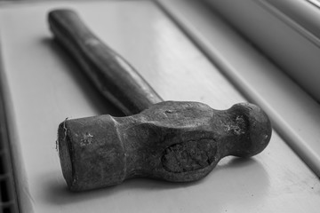 An old hammer head tool with a wooden handle