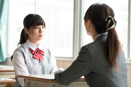 進路相談をする女子学生と女性教師
