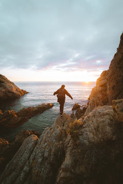 Unrecognizable person standing on cliff near sea