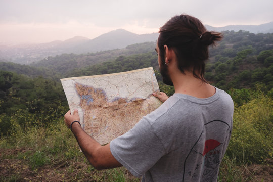 Unrecognizable man reading map in countryside