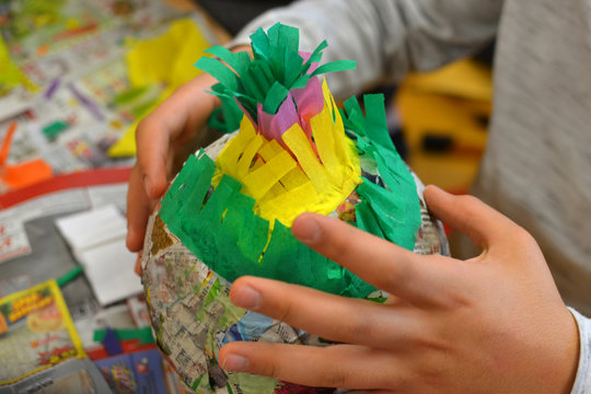 Children hands are making a pinata.