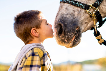 in a beautiful Autumn season of a young boy and horse