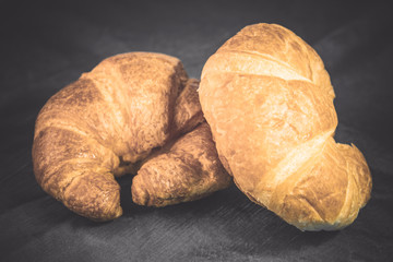 Tasty buttery croissants on old wooden table.