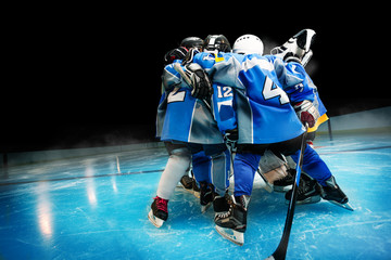 Hockey team standing in circle on ice rink