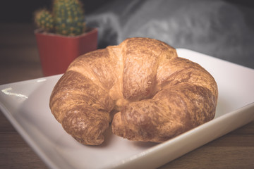 Tasty buttery croissants on old wooden table.