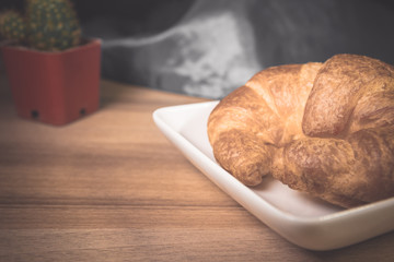 Tasty buttery croissants on old wooden table.