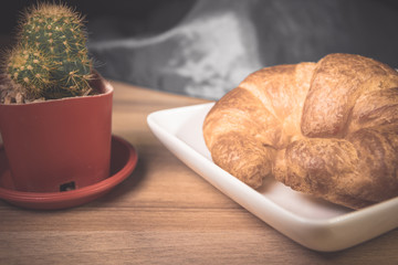 Tasty buttery croissants on old wooden table.