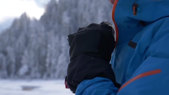 Slow motion - Adult male zipping his winter jacket and looking away