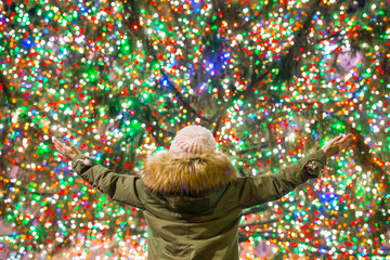 Happy girl on the background of the Rockefeller Christmas tree in New York