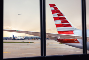 View of airplane fuselage tail through window at airport