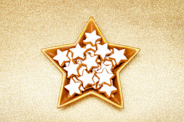 star shaped christmas cookies in a star shaped golden bowl on a golden background