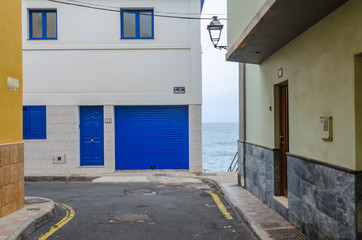 a narrow alley without people with coloured facades